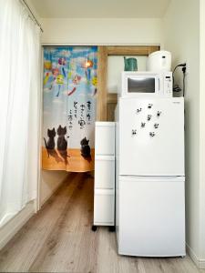 a kitchen with a refrigerator and a microwave at nestay apartment tokyo waseda in Tokyo
