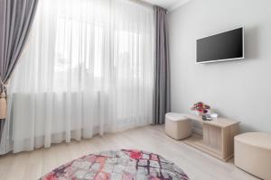 een witte kamer met een groot raam en een televisie bij Venezia Studio Apartment in Oradea