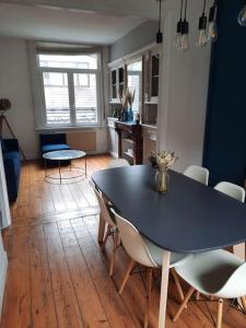 uma sala de jantar com uma mesa preta e cadeiras em Charmante maison 3 chambres avec cour em Lille