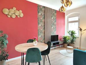 um quarto com uma mesa e cadeiras e uma parede vermelha em tealounge 2 Raum + Küche em Dresden