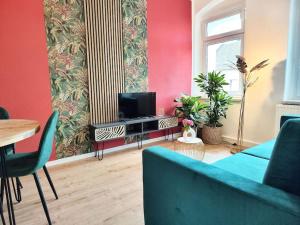 uma sala de estar com um sofá azul e uma televisão em tealounge 2 Raum + Küche em Dresden