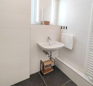 ein weißes Badezimmer mit einem Waschbecken und einem Spiegel in der Unterkunft tealounge 2 Raum + Küche in Dresden