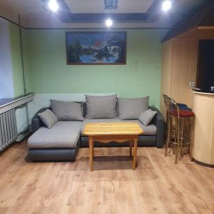 a living room with a couch and a table at Apartament Erfolg 6 in Daugavpils