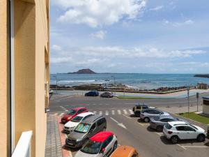 a parking lot with cars parked next to the beach at Mahostly Corralejo Vista Mar in Corralejo
