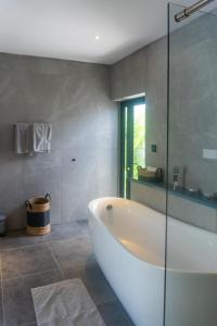 baño con bañera y pared de cristal en Pearl Collection, en Grand Baie