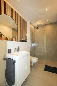 Un baño con lavabo, inodoro y espejo. en TimeTidy III, en Hochheim am Main