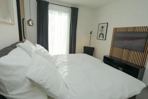 a bedroom with a white bed and a television at TimeTidy III in Hochheim am Main