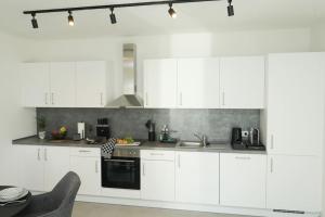 a white kitchen with white cabinets and a sink at TimeTidy III in Hochheim am Main