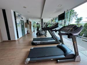 un gimnasio con tres máquinas de correr en una habitación en City Garden Tropicana Condo Naklua en Pattaya North