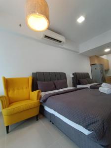 sypialnia z łóżkiem i żółtym krzesłem w obiekcie CL 93B Balcony KLCC View Studio w Kuala Lumpur