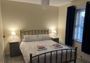 a bedroom with a bed with two towels on it at 3 Bedroom Apartment, Ballymena, The Wee Stop Gap in Ballymena