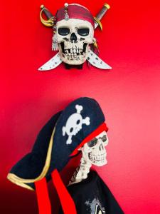 un esqueleto vestido con un disfraz de pirata en un fondo rojo en THE ENCHANTED HOUSE ( 15 min walk to Disney), en Serris