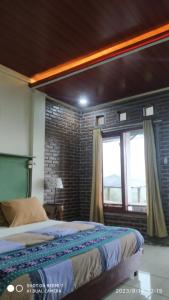 - une chambre avec un lit et un mur en briques dans l'établissement Ecobromo, à Pasuruan