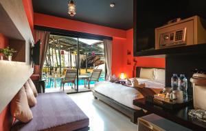 1 dormitorio con 1 cama, mesa y sillas en Bhundhari Chaweng Beach Resort Koh Samui - SHA Plus, en Chaweng