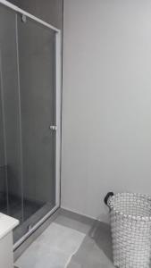 a glass shower door in a bathroom with a trash can at KK'S Haven in Johannesburg