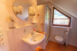 ein Badezimmer mit einem Waschbecken, einem WC und einem Spiegel in der Unterkunft Wein- und Gästehaus Michels in Wolf