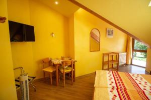 una camera da letto con tavolo e parete gialla di Wein- und Gästehaus Michels a Wolf