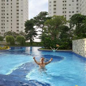 uma mulher a nadar numa piscina numa cidade em Apartemen Educity Pakuwon city Surabaya BACA DESKRIPSI DULU em Surabaya