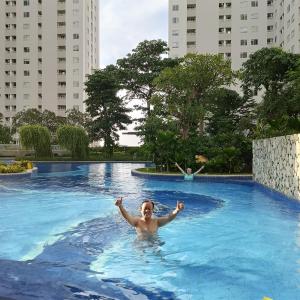 a woman swimming in a swimming pool in a city at Apartemen Educity Pakuwon city Surabaya BACA DESKRIPSI DULU in Surabaya