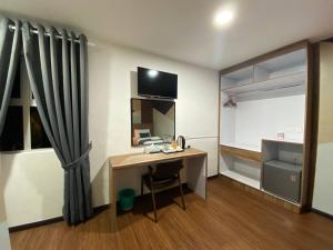 a room with a desk with a computer and a window at Assalam Hotel in Kota Bharu