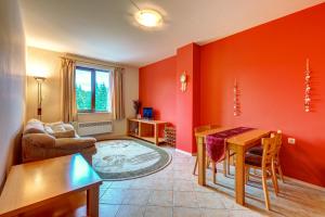 - un salon avec des murs rouges, une table et des chaises dans l'établissement Panorama, à Vodata
