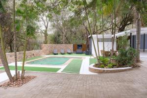 una piscina en un patio con árboles en Kadima Safari Lodge, en Hoedspruit