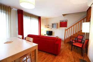 uma sala de estar com um sofá vermelho e uma mesa em Adonis Divonne-Les-Bains Résidence Du Lac em Divonne-les-Bains