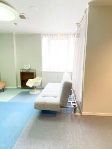 福山的住宿－ROSE ROOM，带沙发和窗户的客厅