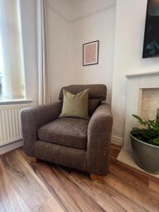 a chair with a pillow sitting in a living room at Liverpool Ivy House - 4 Bedrooms in Liverpool