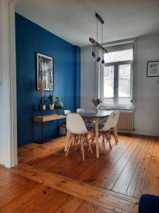 uma sala de jantar com paredes azuis e uma mesa e cadeiras em Charmante maison 3 chambres avec cour em Lille