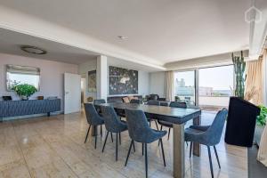 a dining room and living room with a table and chairs at Penthouse Terrace Frankfurt in Frankfurt/Main +7 photos