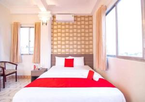 ein Schlafzimmer mit einem Bett mit einer roten Decke in der Unterkunft Tan Hoang Long Hotel in Ho-Chi-Minh-Stadt