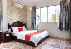 a bedroom with a bed with a red and white blanket at Tan Hoang Long Hotel in Ho Chi Minh City