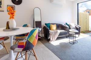 Vibrant Inner City Escape Near New Regent Street في كرايستشيرش: غرفة معيشة مع طاولة وكراسي