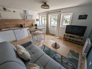 a living room with a couch and a table and a kitchen at Le Studio Jungle in Digoin