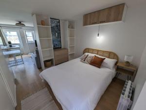 Schlafzimmer mit einem großen weißen Bett und einem Schreibtisch in der Unterkunft Le Studio Jungle in Digoin