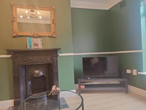 uma sala de estar com lareira e televisão em Modern 4 Bedroom Townhouse in City Centre em Dublin
