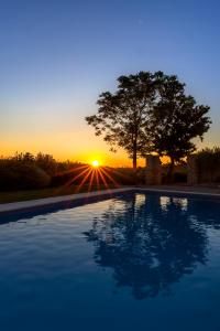 a swimming pool with the sunset in the background at Grano - Casa Bella Vista in Force