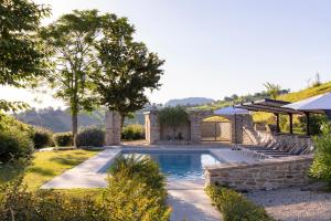 a swimming pool in a yard with a stone house at Grano - Casa Bella Vista in Force