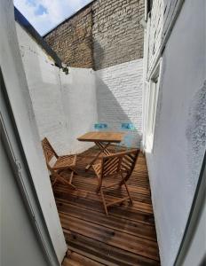 um pátio com uma mesa e cadeiras numa varanda em Charmante maison 3 chambres avec cour em Lille