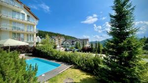 a view of a resort with a swimming pool and a tree at Apartament Ischgl 35 in Sienna