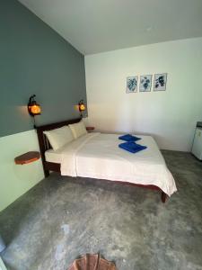 Zabit Bungalow في كو لانتا: غرفة نوم بسريرين وصورتين على الحائط