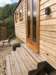 a wooden deck on the side of a cabin at No 1 Hut Lane, a cosy Hut, heating, hot water and a magnificent view for 2 in Dorchester