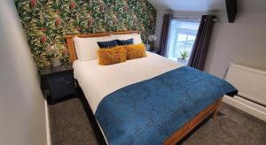 - une chambre avec un grand lit et une couverture bleue dans l'établissement The George Country Inn, Wath, à Wath