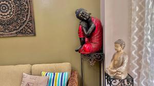 a red statue on a wall next to a couch at Pico De Loro 2BR Carola B Unit with Lagoon View in Nasugbu