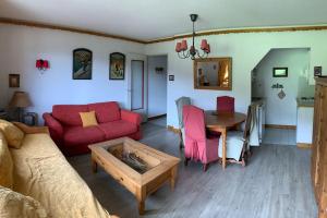uma sala de estar com um sofá vermelho e uma mesa em Résidence Saboia A29 Clés Blanches Courchevel em Courchevel