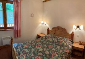 um quarto com uma cama e duas mesas de cabeceira e uma janela em Résidence Saboia A29 Clés Blanches Courchevel em Courchevel