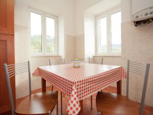 a red and white checkered table and chairs in a kitchen at Spacious home surrounded by nature in Sesta Godano