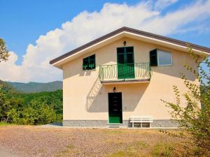 een huis met een groene deur en een balkon bij Spacious home surrounded by nature in Sesta Godano