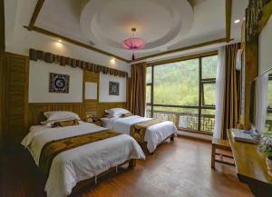 um quarto com 2 camas e uma grande janela em Zhangjiajie Memory Inn em Zhangjiajie
